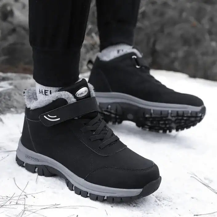 Ein Mann trägt Schwarz Ergonomische Winter-Barfußschuhe von Vanea Barfußschuhe im Schnee